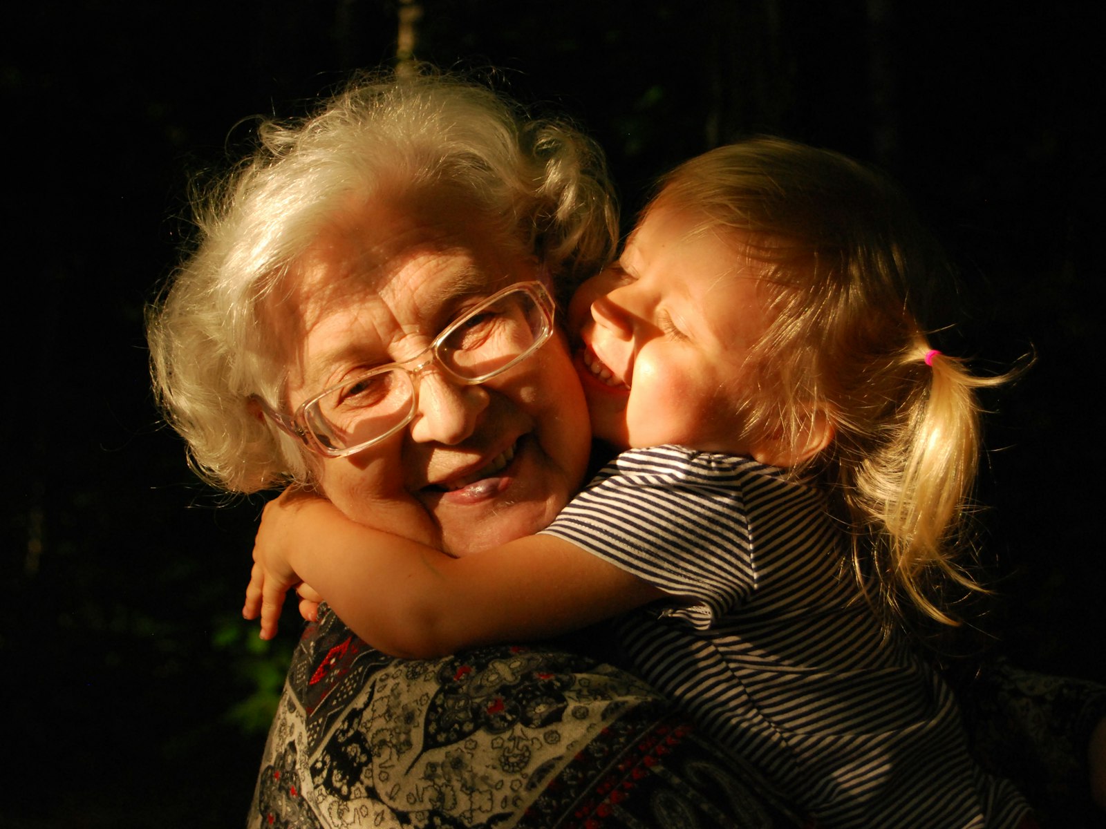 A grandmother hugging a young child